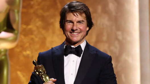 Tom Cruise vestido de esmoquin y con un premio Oscar en la mano
