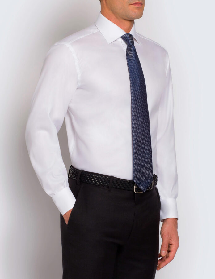 Modelo vistiendo una camisa de traje, sin chaqueta y con corbata para ilustrar un texto sobre cómo debe ser la corbata de un traje