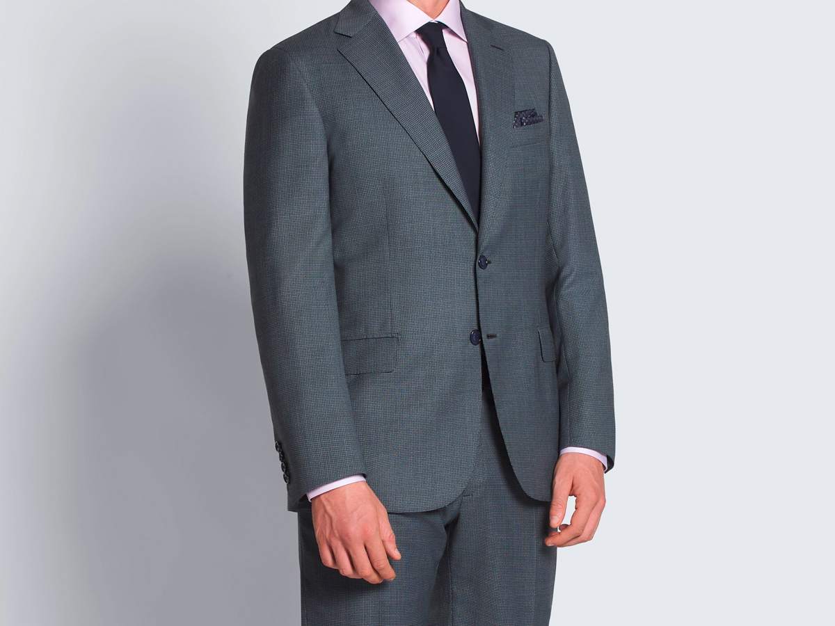 Hombre vestido con un traje gris y camisa roja. El traje le queda perfecto, con las medidas adecuadas.