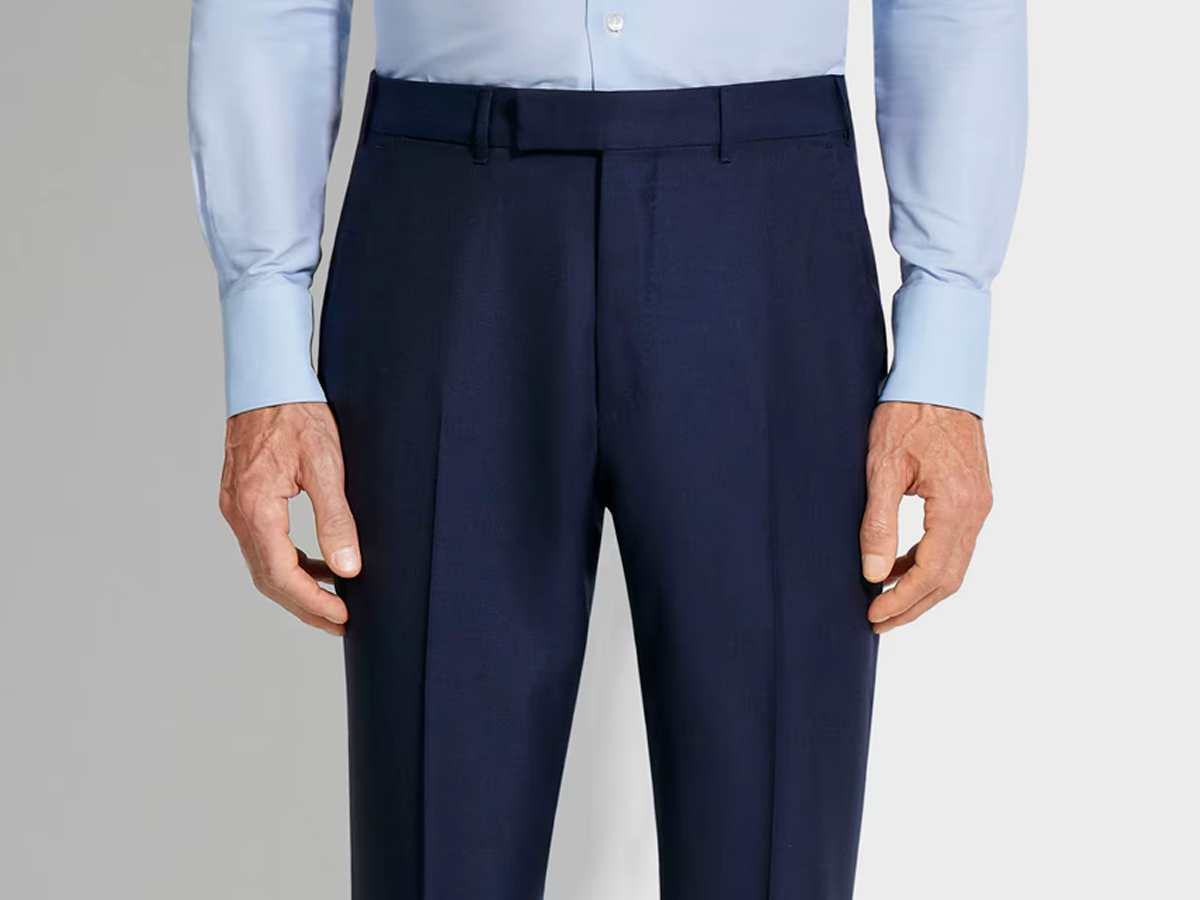 Plano detalle de la cintura de un pantalón de traje sin cinturón.