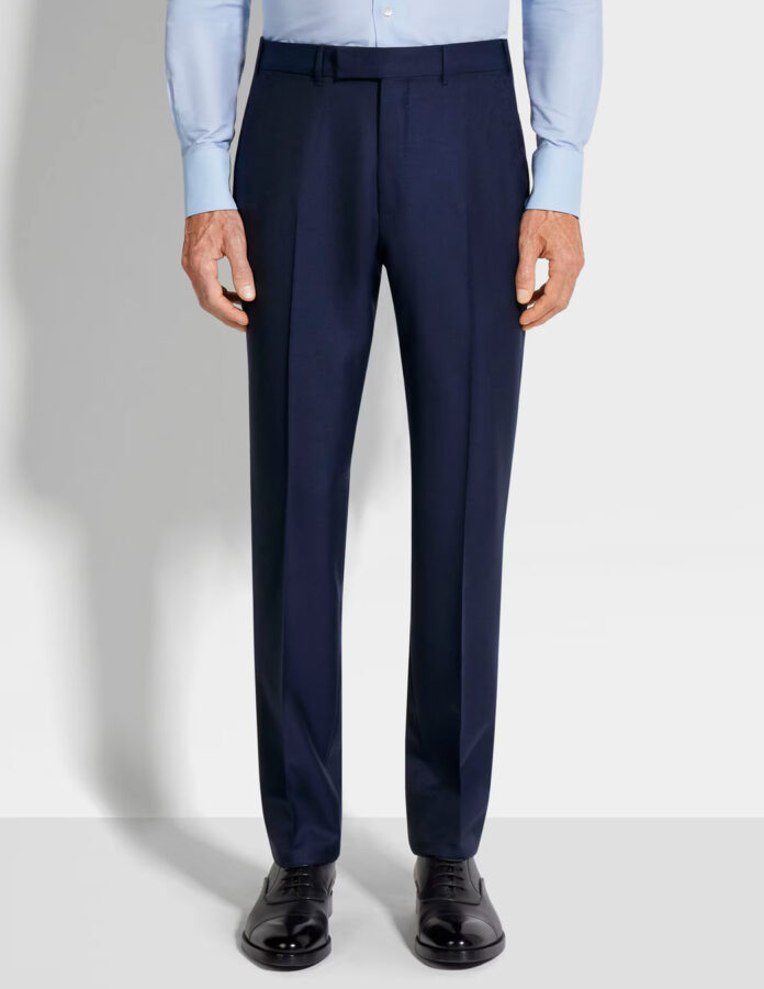 Imagen del tren inferior de un hombre vistiendo un pantalón de traje con el largo adecuado.