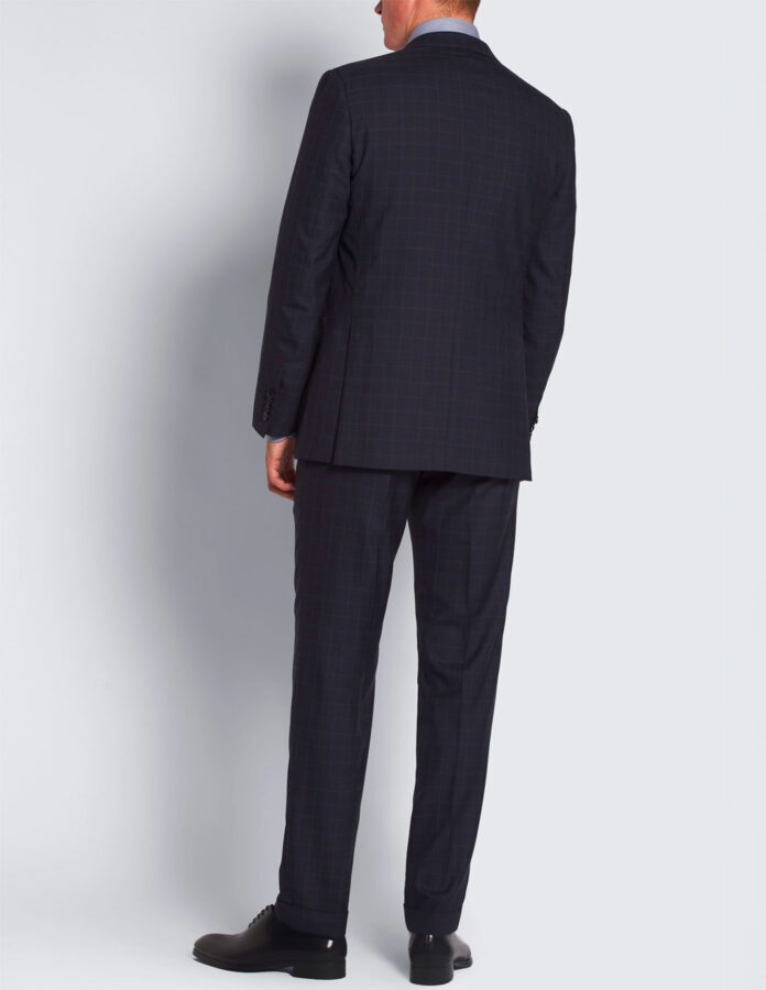 Hombre muy elegante visto de espaldas vistiendo un traje azul marino de cuadros ventana.