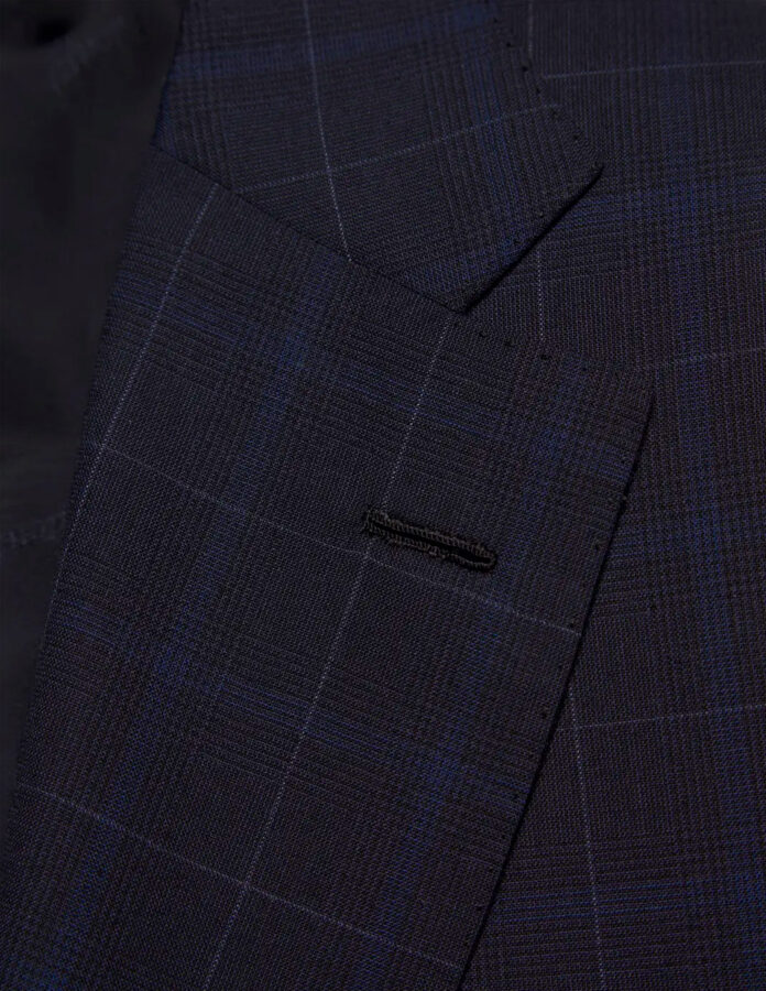 Primer plano de la solapa de una chaqueta de traje mostrando el pespunte y la textura