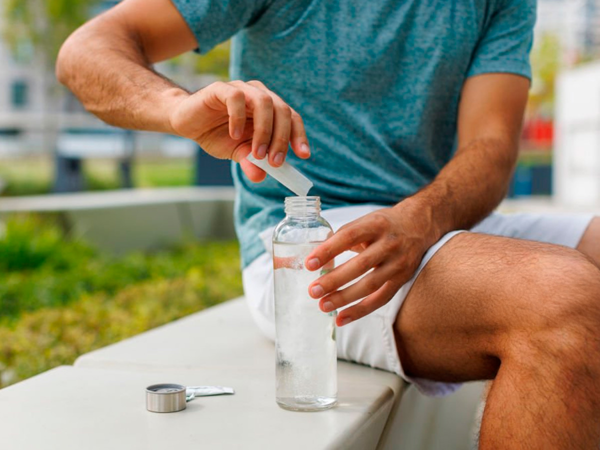 hombre tomando suplemento deportivo en una bebida mientras hace deporte