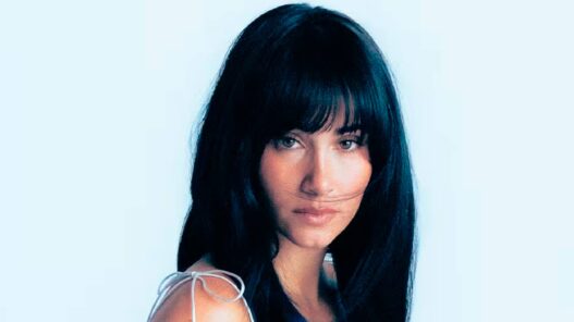 Retrato de la cantante española Aitana con fondo azul claro