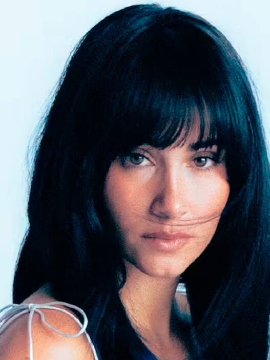 Retrato de la cantante española Aitana con fondo azul claro