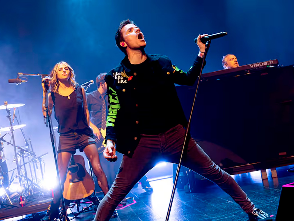 El cantante Dani Martín sobre un escenario cantando, con las piernas muy separadas y agarrando el micrófono con fuerza