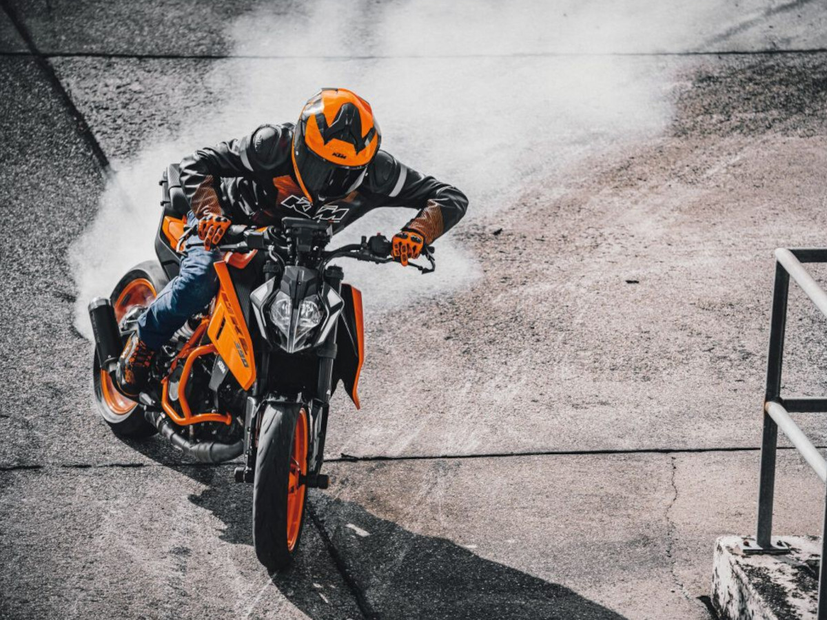hombre conduciendo una KTM 390 Duke naranja