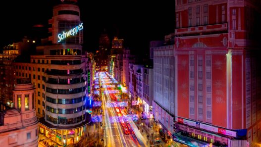 Vista aérea de la Gran Vía de Madrid de noche, con el edificio Schweppes en primer plano iluminado