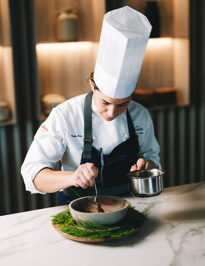 Cocinera preparando uno de los pases vegetales del menú degustación en Toledo.
