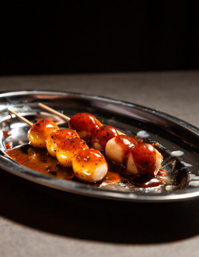 Dango de vainilla y sésamo negro del restaurante Tetsu, presentado con un glaseado brillante.