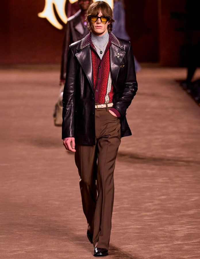 Look de Amiri otoño-invierno 2025 con jersey gris de cuello alto, camisa burdeos y chaqueta de cuero.