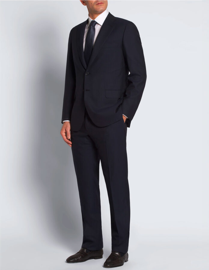 hombre posando con un traje muy elegante azul marino de la firma Brioni