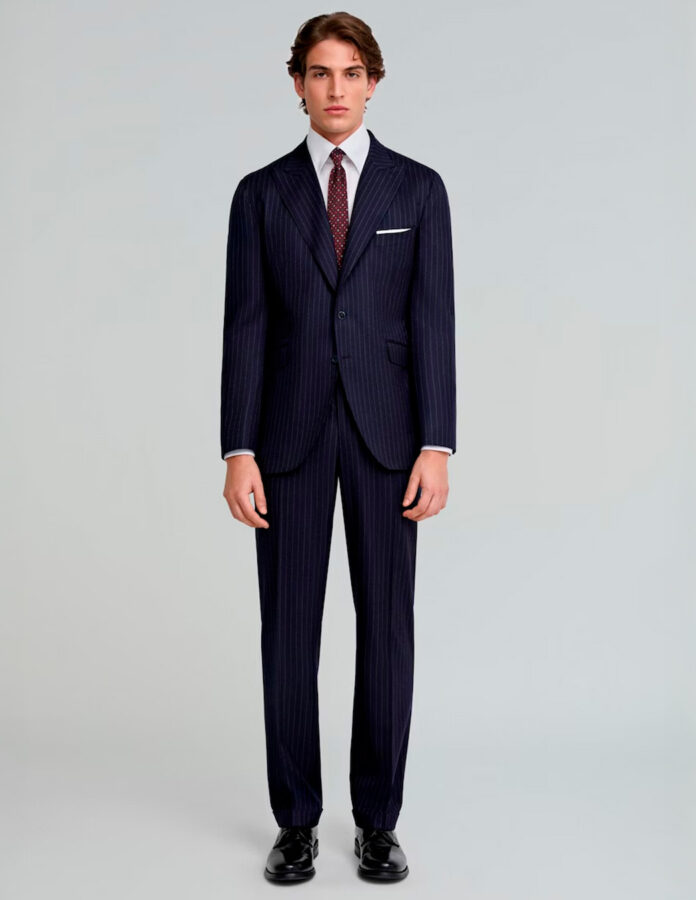 Modelo masculino vestido con un traje muy elegante azul oscuro de rayas de la marca Scalpers
