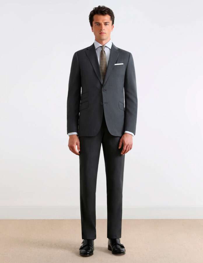 Modelo masculino vestido muy elegante con un traje color gris claro y zapato de doble hebilla