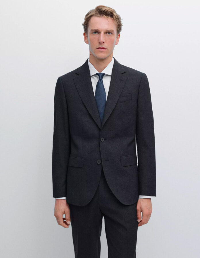 Vista de medio cuerpo de un hombre con traje azul marino de Massimo Dutti.