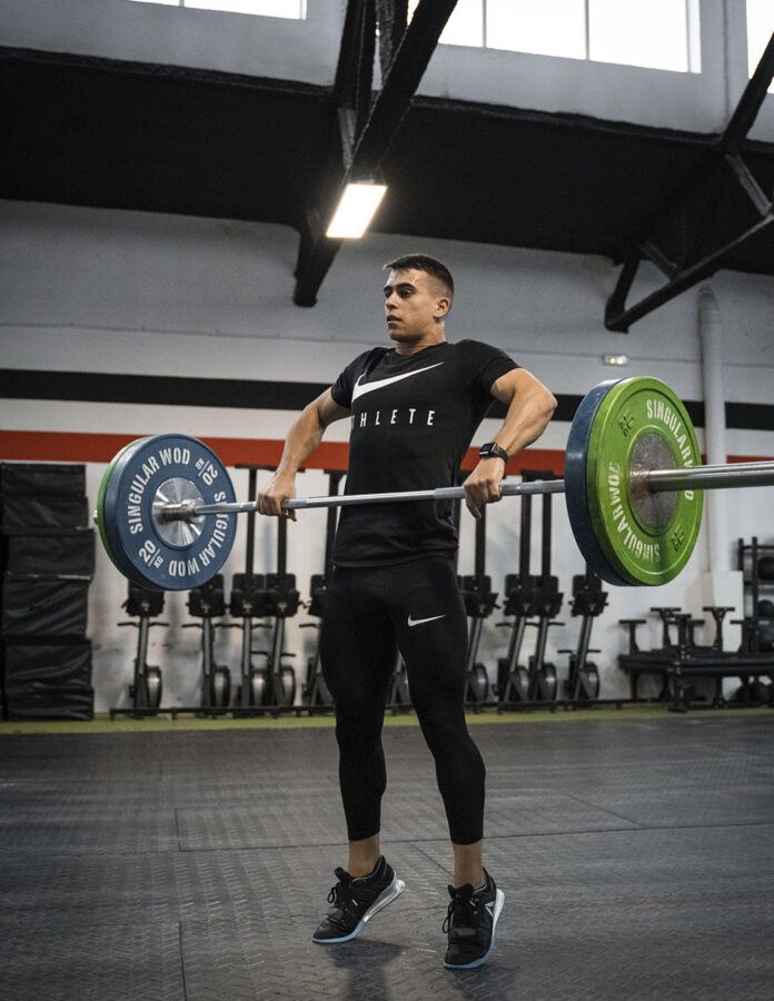 Adrián Sandoya ejecutando un movimiento de halterofilia con barra y discos en el box