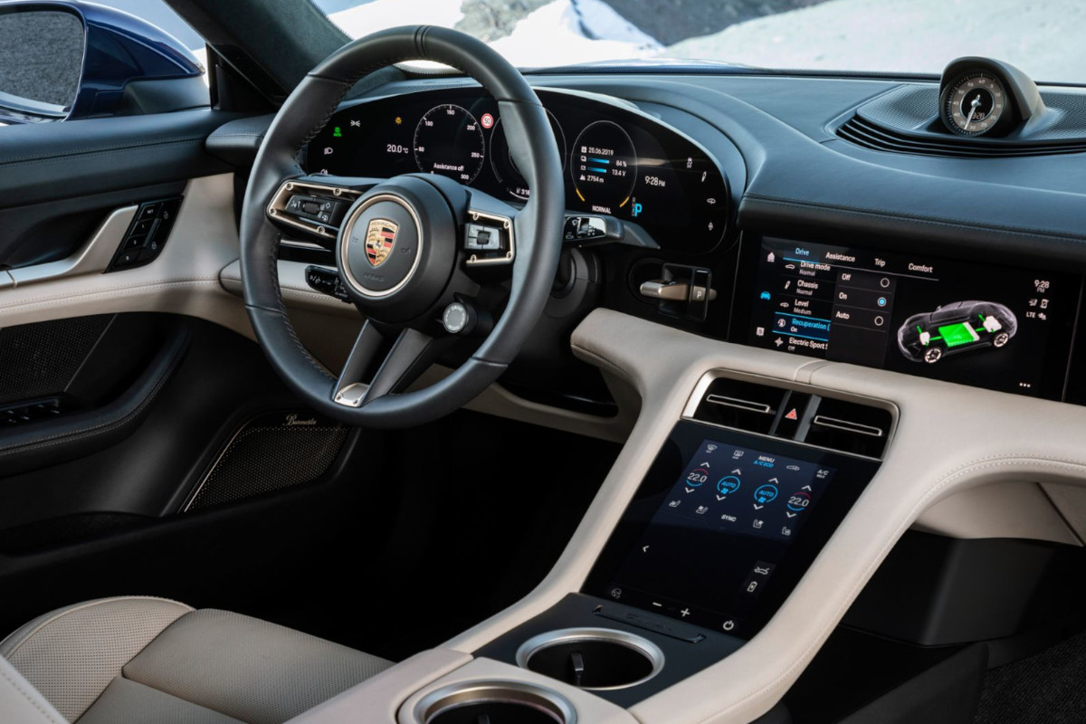 Interior del Porsche Taycan con pantalla digital y ausencia de cambio manual en un coche eléctrico de altas prestaciones