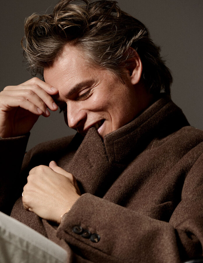 El cantante venezolano Carlos baute posa sentado en una silla vestido muy elegante en una sesión de fotos para la revista Rísbel Magazine.