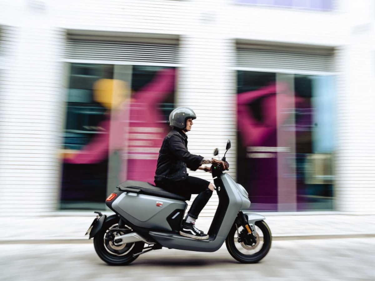 Scooter NIU MQi GT Evo en marcha por una calle de ciudad.
