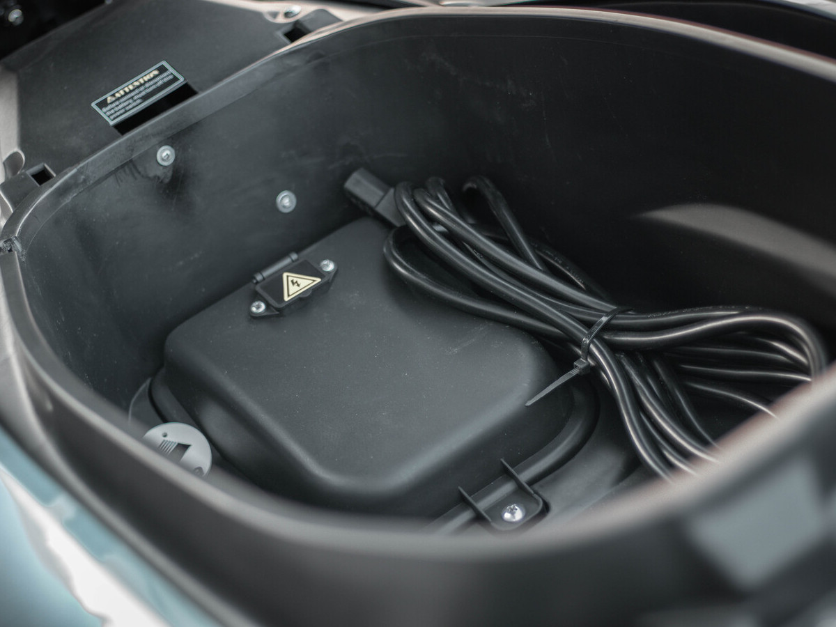 Espacio de almacenamiento bajo el asiento del Velca One con cable de carga.