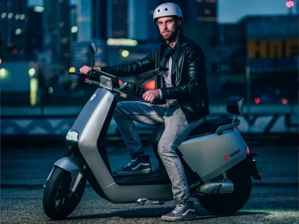 Conductor sobre una Yadea G5 Pro gris de noche en la ciudad.