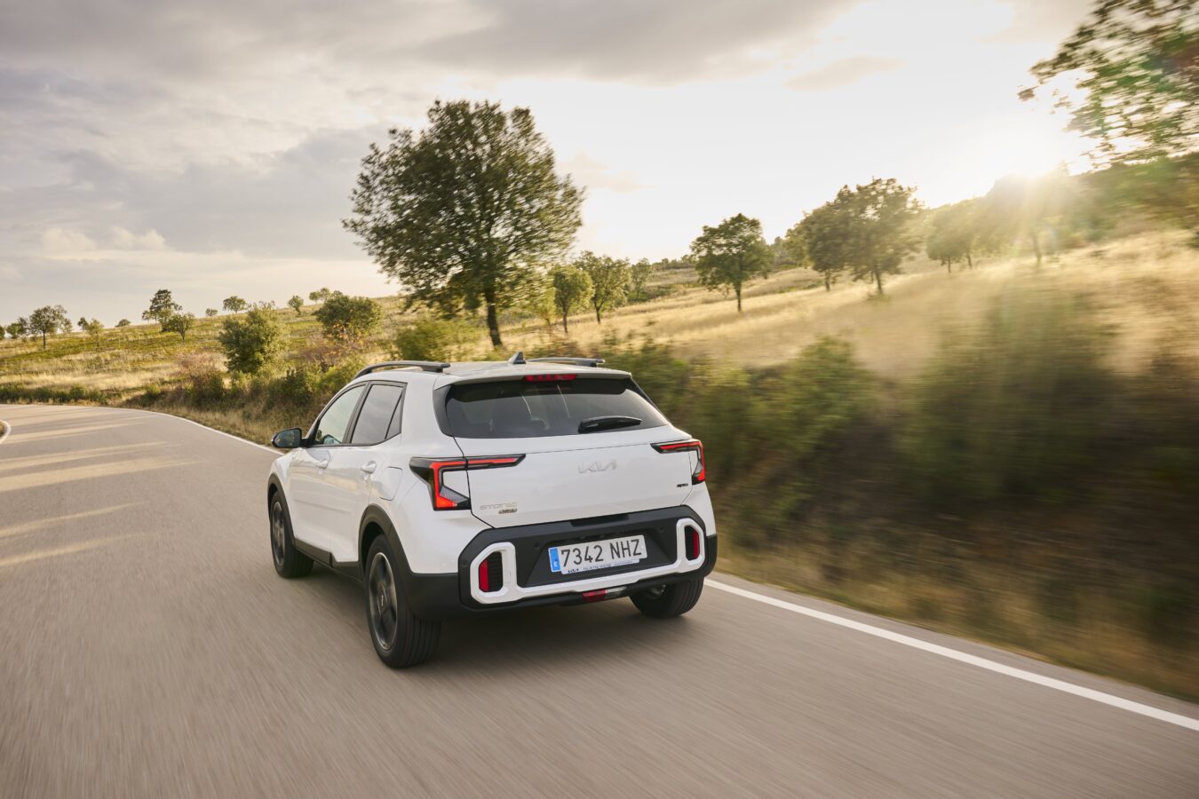 Kia Stonic 2025 facelift blanco, vista trasera en carretera con nuevo portón y pilotos rediseñados