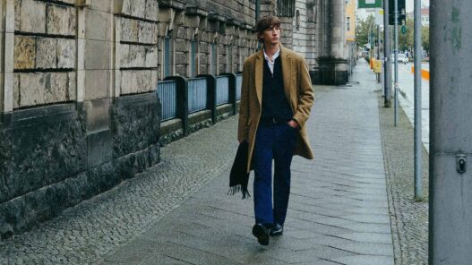 Modelo caminando por la calle con un abrigo de lana largo color camel y un look para el día a día.