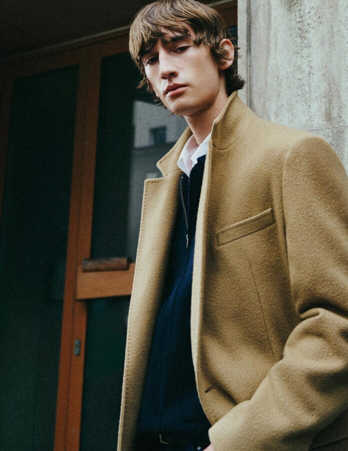 Primer plano del abrigo largo camel de Scalpers en combinación con prendas oscuras