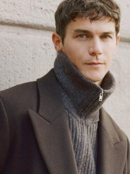 Modelo vestido con un abrigo largo de lana marrón de Mango.