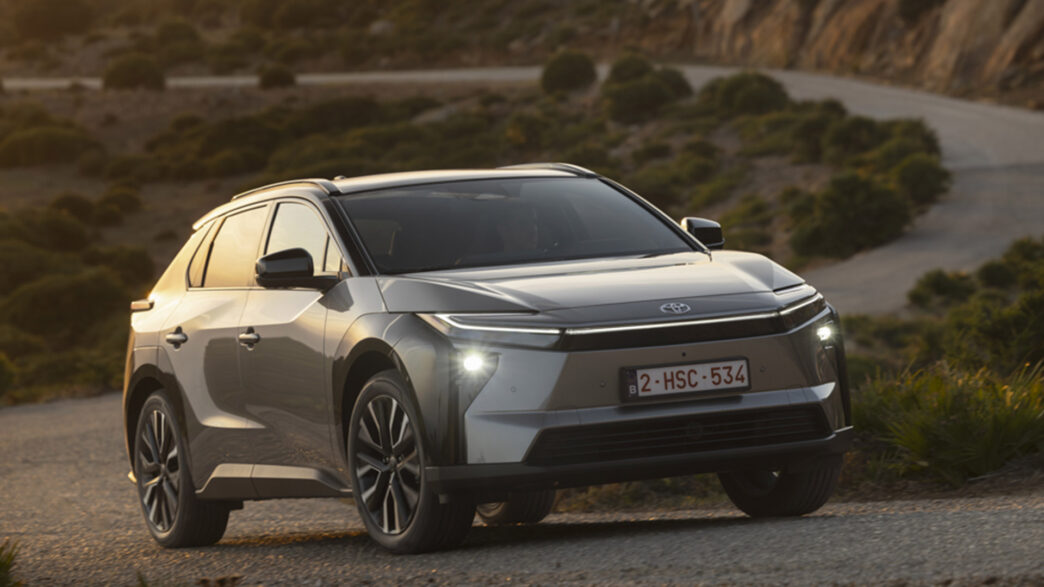 Toyota bZ4X avanzando por una carretera de montaña al atardecer.