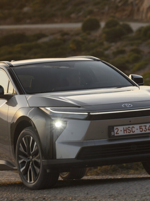 Toyota bZ4X avanzando por una carretera de montaña al atardecer.
