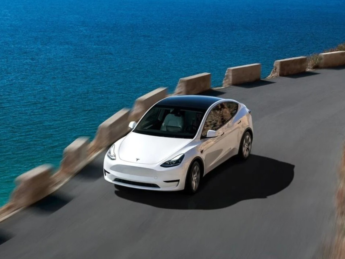 Tesla Model Y Long Range blanco circulando por una carretera de costa
