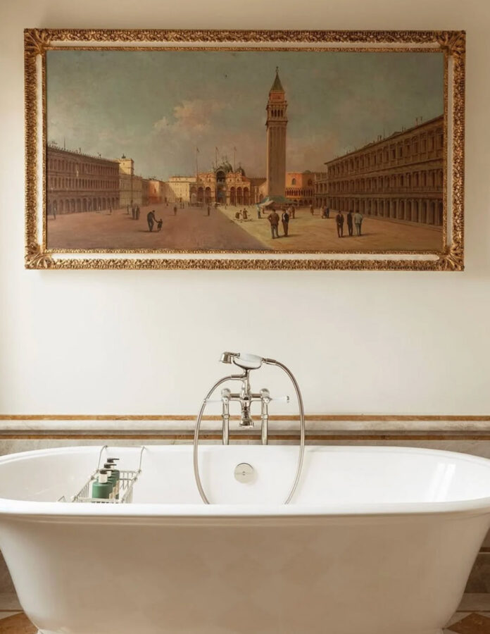 Baño de la suite del hotel Airelles Palladio Venezia con una elegante bañera y una obra de arte en la pared