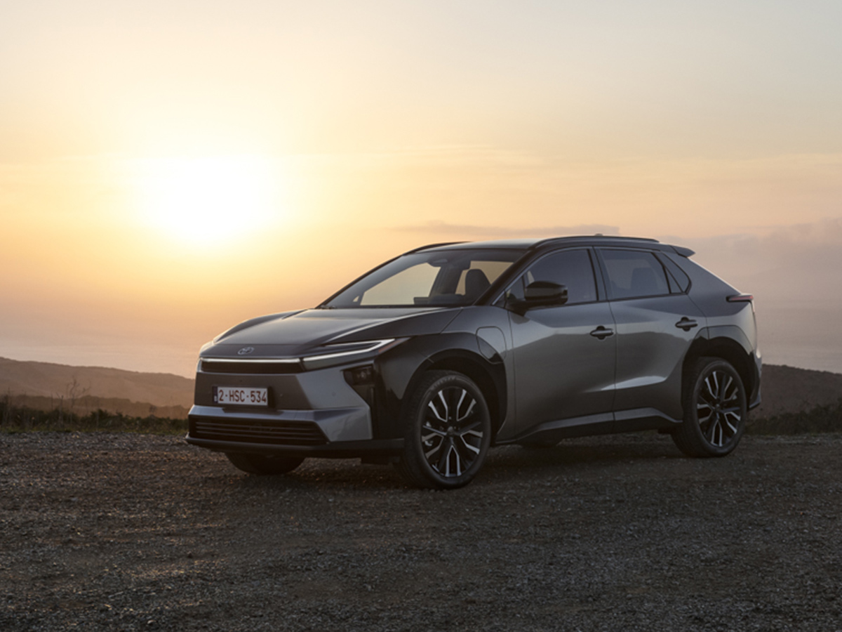 Toyota bZ4X estacionado al atardecer con la silueta del SUV recortada frente al horizonte.