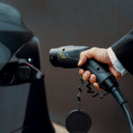 Qué coche eléctrico tiene la mejor batería en 2025: las 10 tecnologías que marcan el camino a la electrificación hombre cargando un coche eléctrico imagen apertura tema qué coche eléctrico tiene la mejor batería apertura