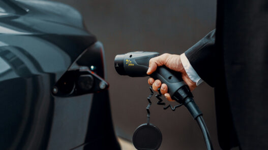hombre cargando un coche eléctrico imagen apertura tema qué coche eléctrico tiene la mejor batería apertura