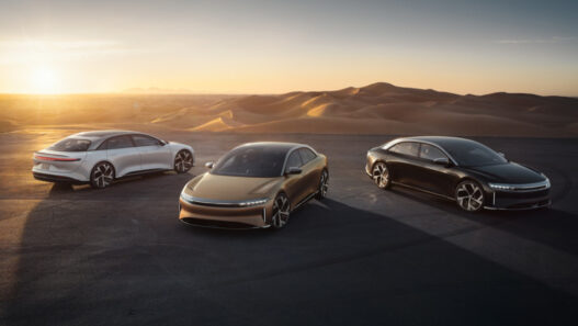 Tres coches Lucid Air Grand Touring aparcados en un monte al atardecer