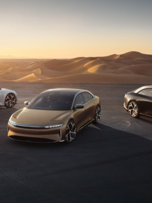 Tres coches Lucid Air Grand Touring aparcados en un monte al atardecer