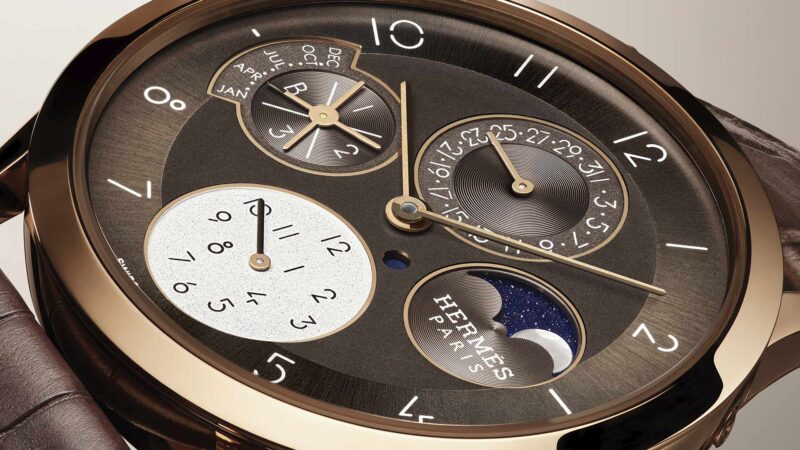 Primer plano del Slim d’Hermès Quantième Perpétuel con esfera marrón galvánico y fases lunares de nácar