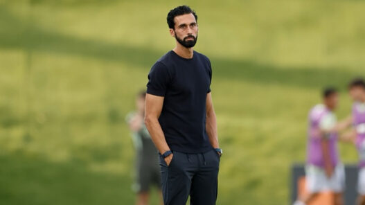 Álvaro Arbeloa en el campo de entrenamiento del Real Madrid con camiseta negra ajustada y pantalón técnico oscuro