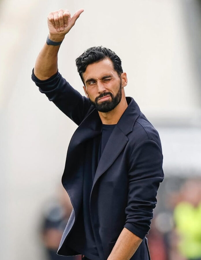 Retrato de Álvaro Arbeloa con americana azul marino y camiseta oscura de estilo deportivo