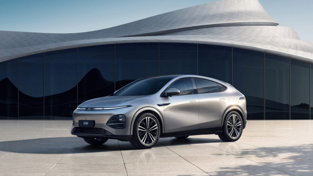 Xpeng gris aparcado frente a un edificio vanguardista