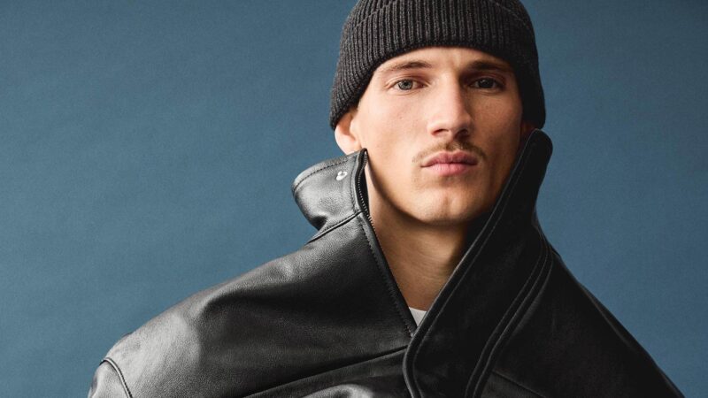 Modelo masculino posa vestido con una cazadora de piel color negro de Zara