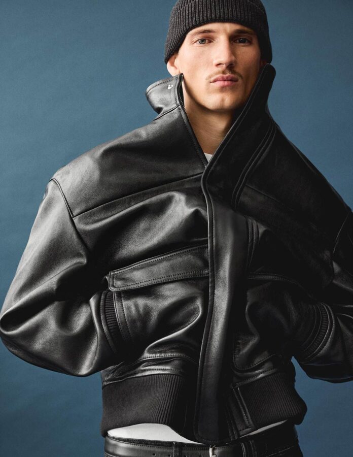 Modelo masculino posando vestido con una cazadora piel color negro de Zara