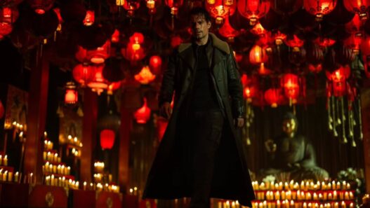 Henry Cavill vestido de negro con un fondo de luces rojas en una escena del remake de Los Inmortales.