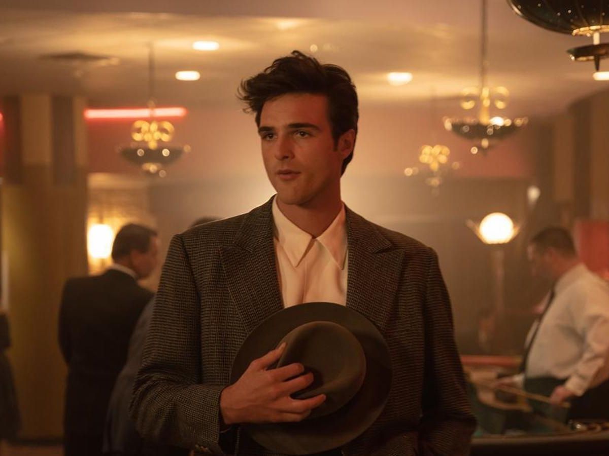 Jacob Elordi con traje y sosteniendo un sombrero con la mano derecha en la película Indomables.