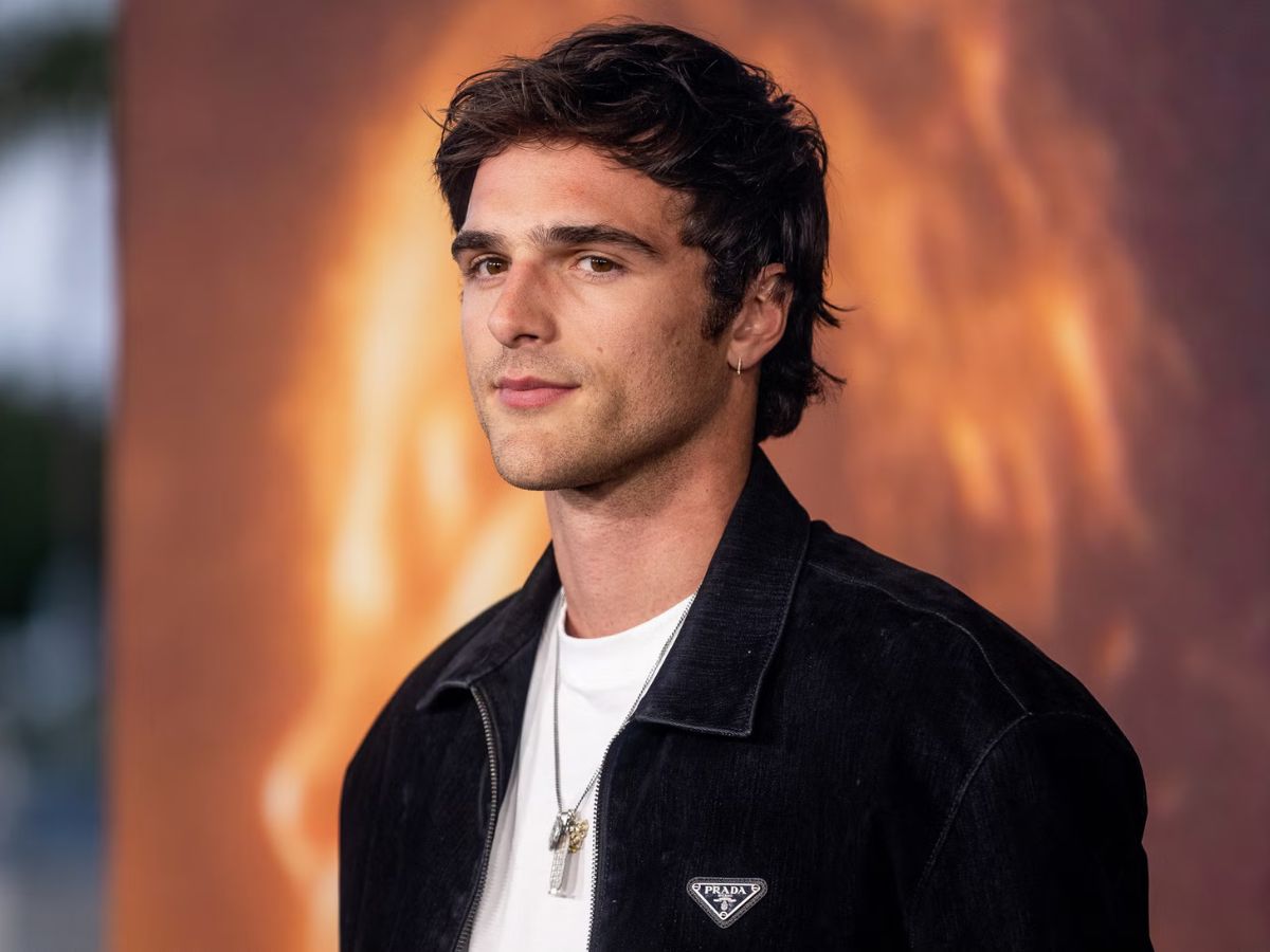 Jacob Elordi con chaqueta negra y camiseta blanca posando en un photocall.