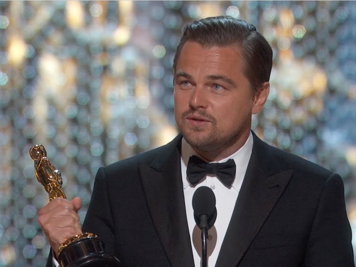 Leonardo DiCaprio con traje negro y pajarita recogiendo el Oscar que ganó en 2016.