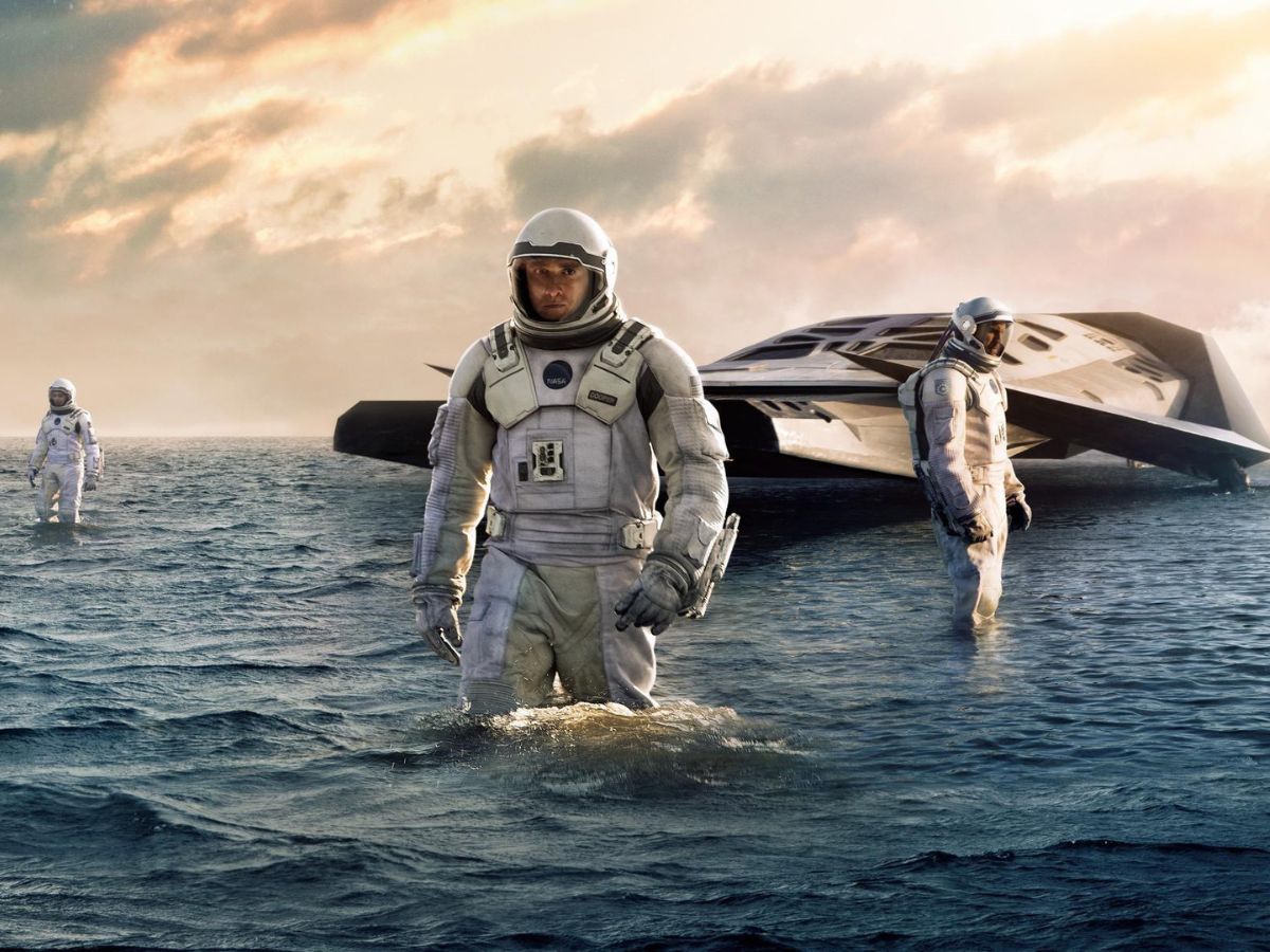 Matthew McConaughey con un traje de astronauta y detrás Jessica Chastain y una nave espacial en una escena de Interstellar.